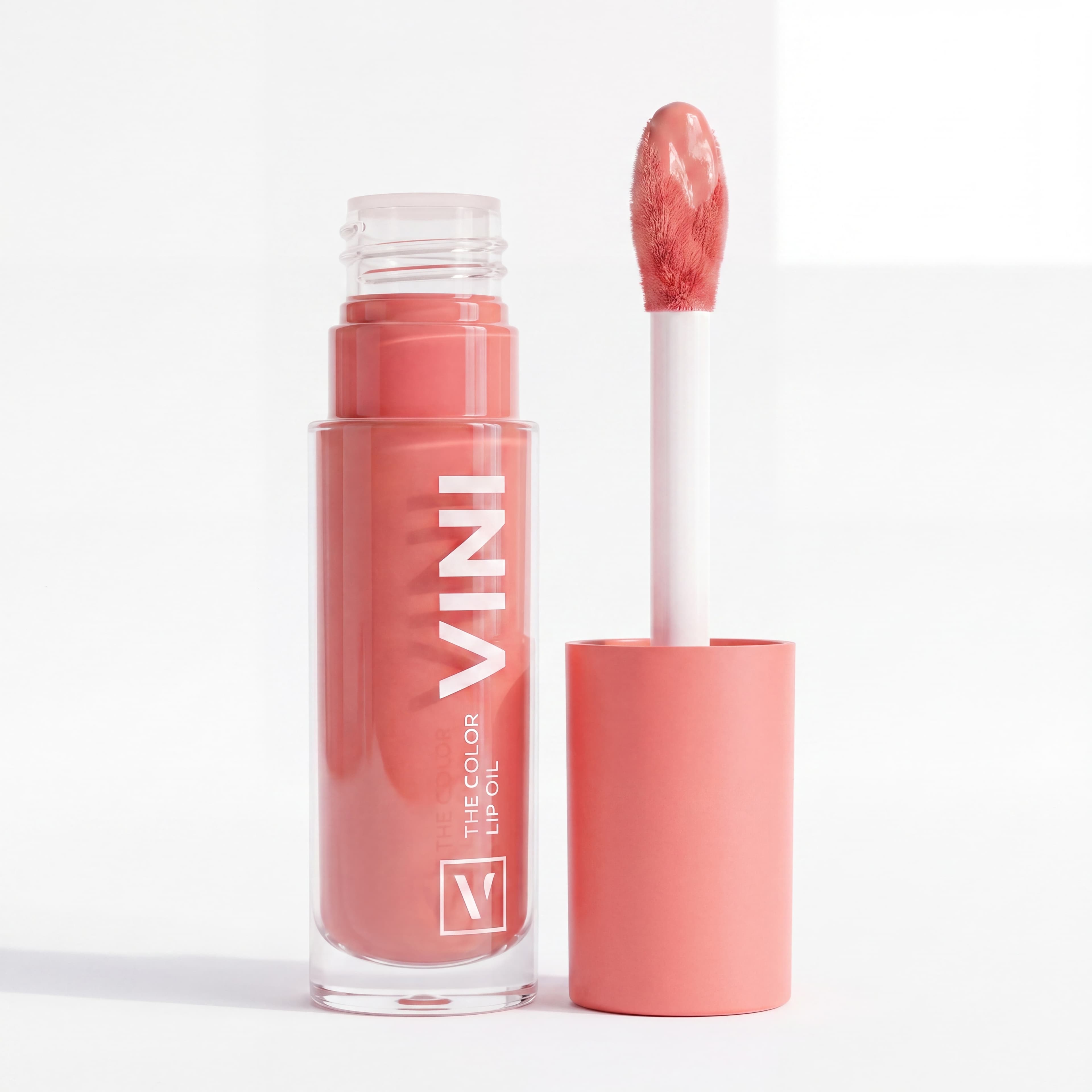 Botella de lip oil abierta con aplicador mostrando el producto desde un ángulo alternativo