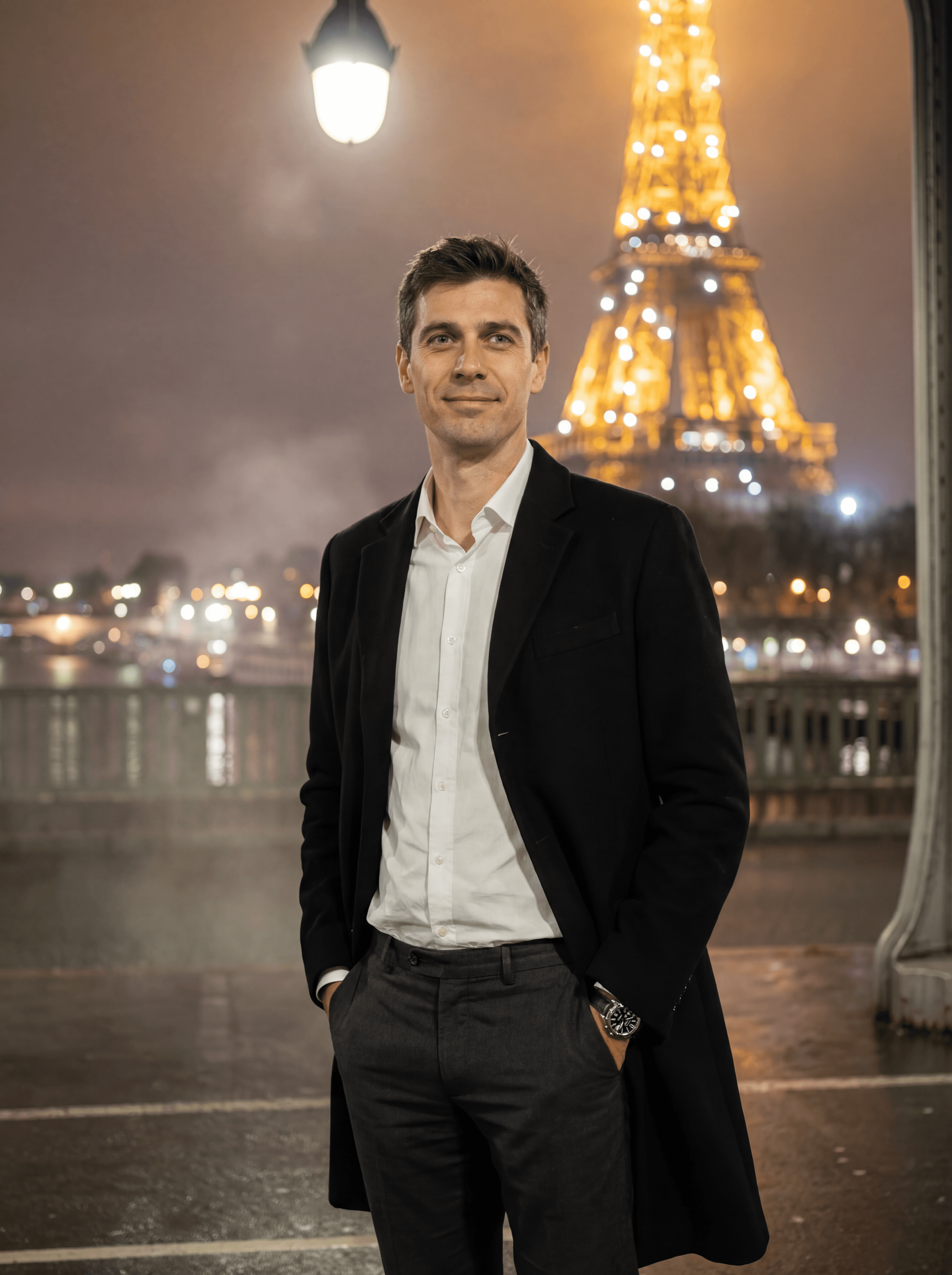Example: man in elegant coat near illuminated Eiffel Tower at night