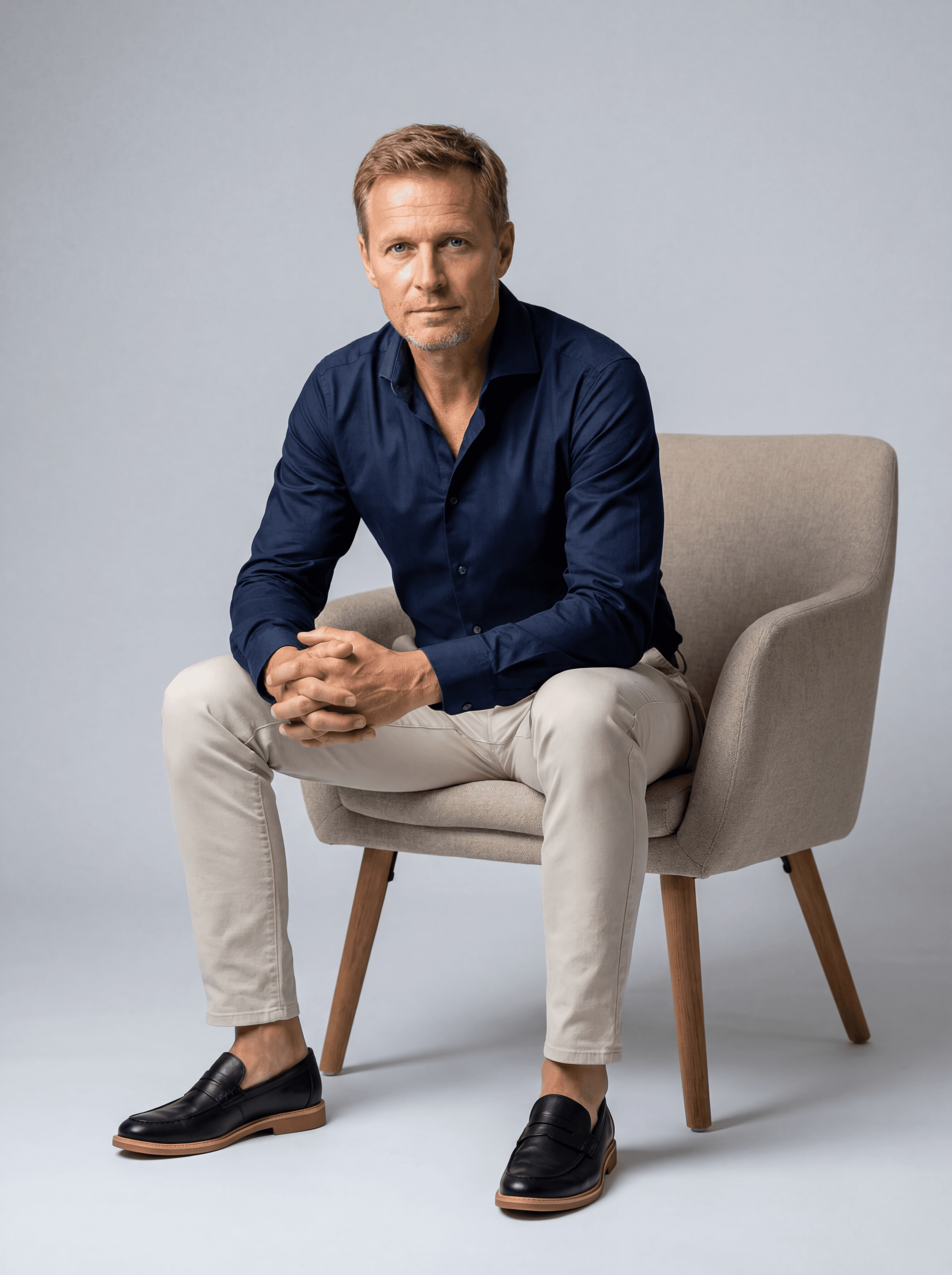 Example: man portrait seated on a modern armchair in studio