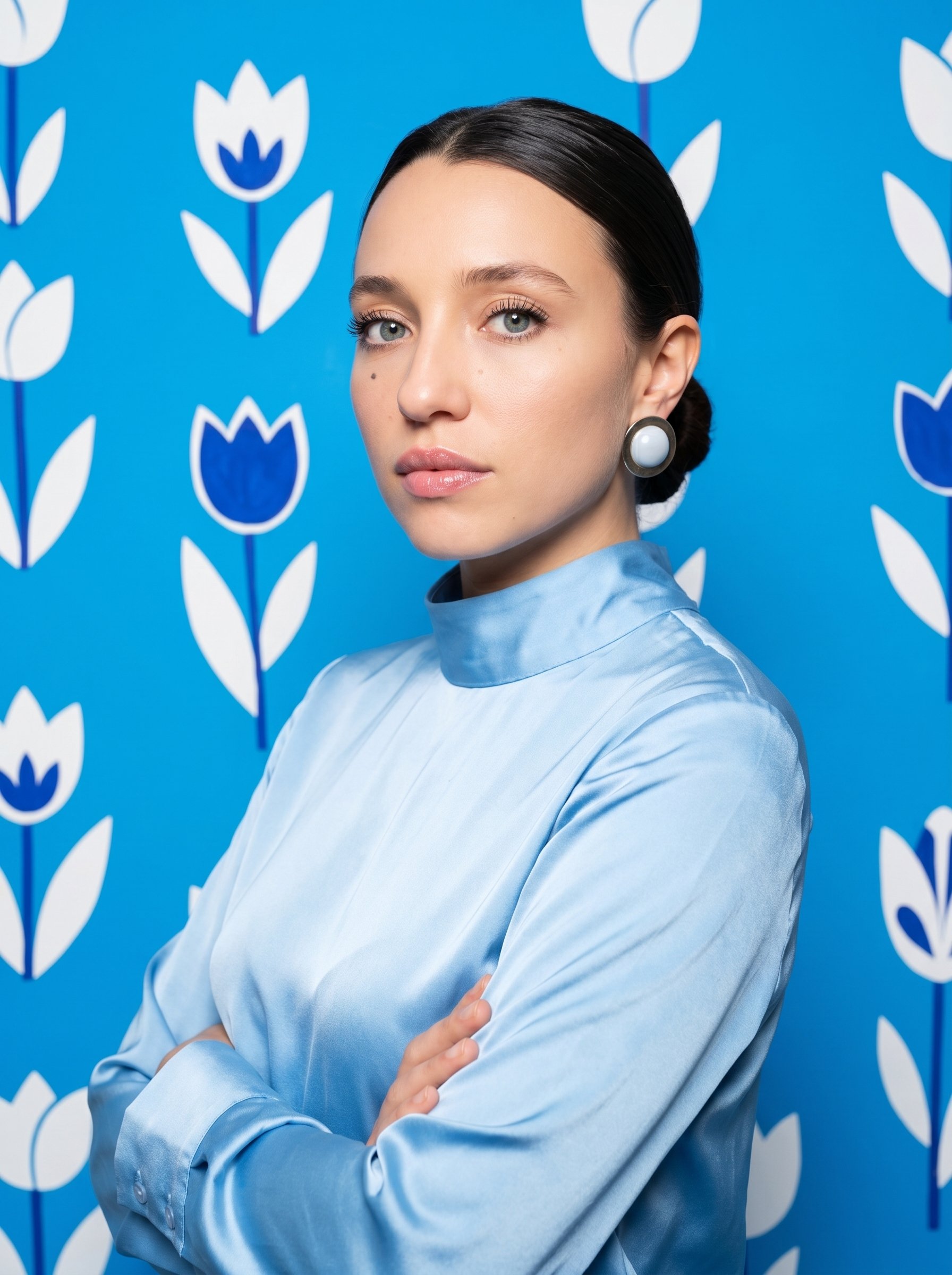 Mujer con una blusa celeste frente a un fondo floral azul y blanco