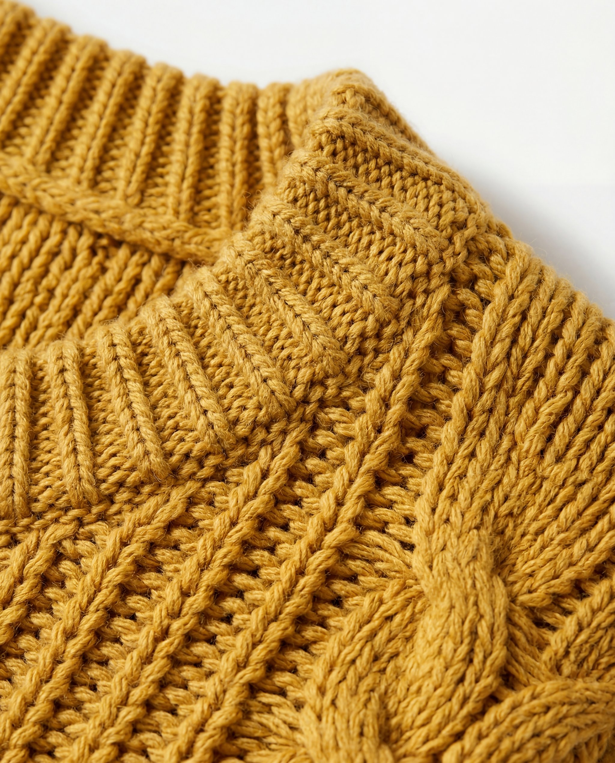 Macro detail photo of the ribbed collar and knit texture of a mustard-yellow oversized sweater