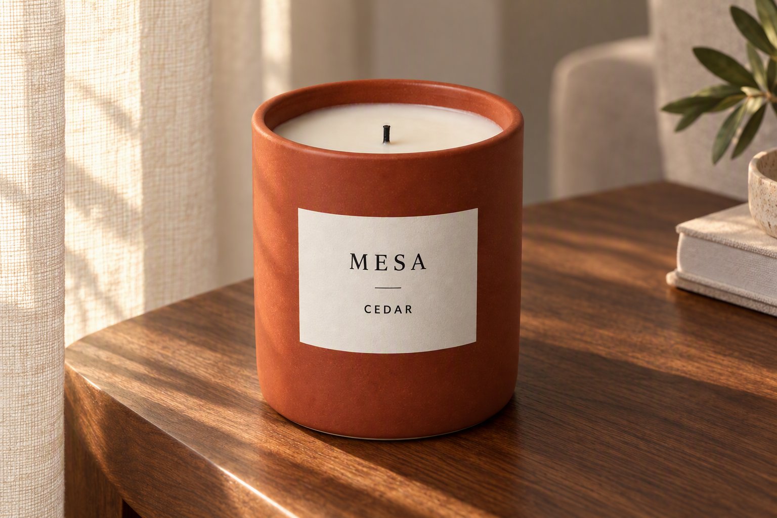 MESA Cedar terracotta candle on a walnut table beside a window in soft daylight