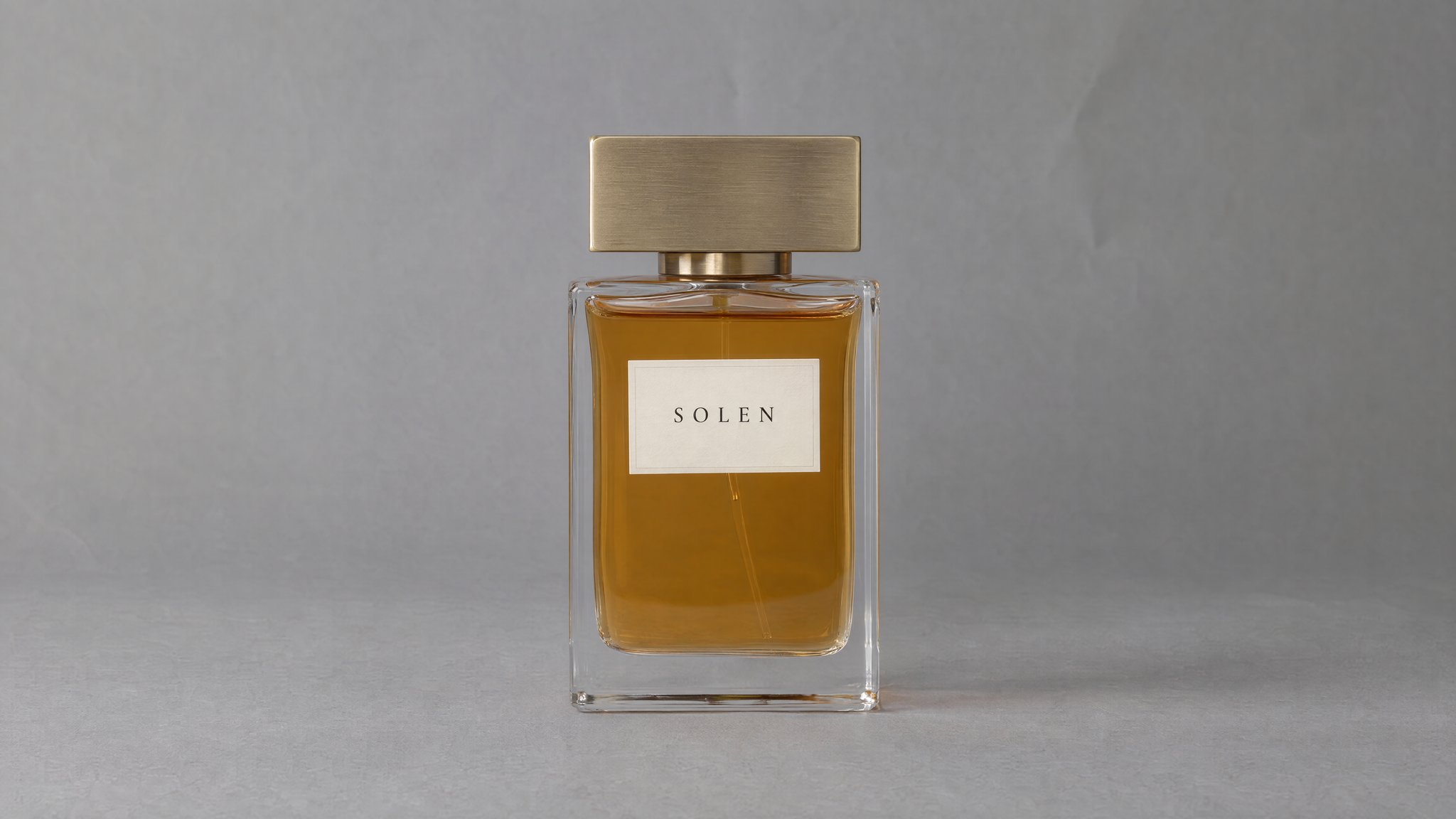 Frasco de perfume SOLEN con líquido ámbar y tapa de latón sobre papel gris, generado con IA